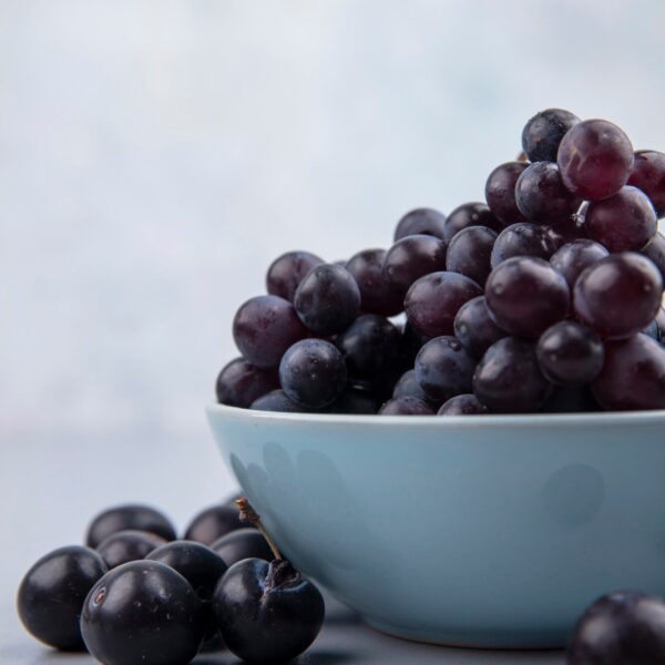side view fresh black grapes blue bowl grey background 141793 49514